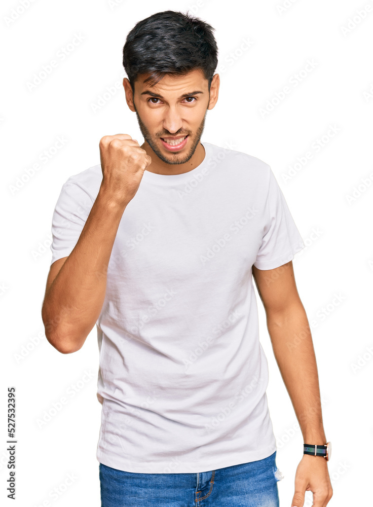Young handsome man wearing casual white tshirt angry and mad raising fist frustrated and furious while shouting with anger. rage and aggressive concept. Young handsome man wearing casual white tshirt angry and mad raising fist frustrated and furious while shouting with anger. rage and aggressive concept.