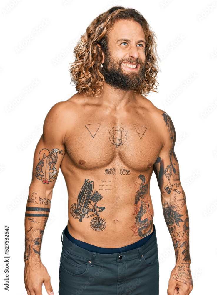 Fototapeta premium Handsome man with beard and long hair standing shirtless showing tattoos angry and mad screaming frustrated and furious, shouting with anger. rage and aggressive concept.