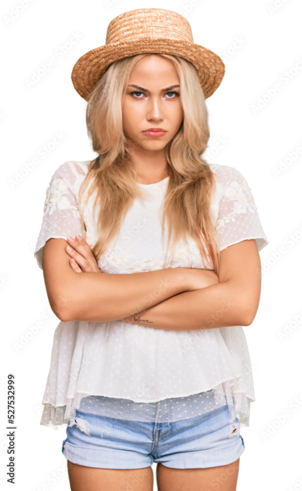 Young blonde girl wearing summer hat skeptic and nervous, disapproving expression on face with crossed arms. negative person. Young blonde girl wearing summer hat skeptic and nervous, disapproving expression on face with crossed arms. negative person.