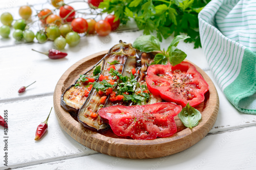 Spicy salad of fried eggplant and fresh tomatoes. Grilled vegetables.