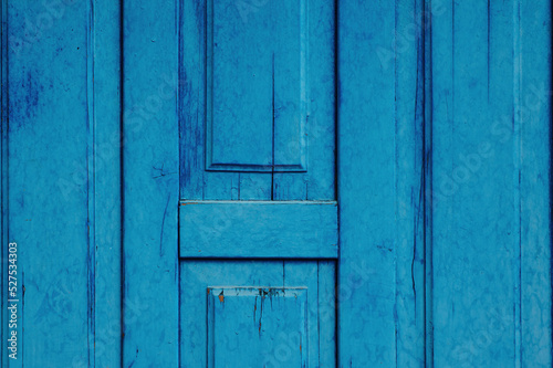 Fragment of an old wooden door painted blue. Background, texture for design. © Oleg Kozlovskiy