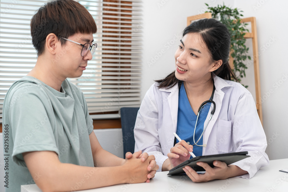 Female doctor physician is taking notes on tablet and writing prescription while asking symptom Female doctor physician is taking notes on tablet and writing prescription while asking symptom