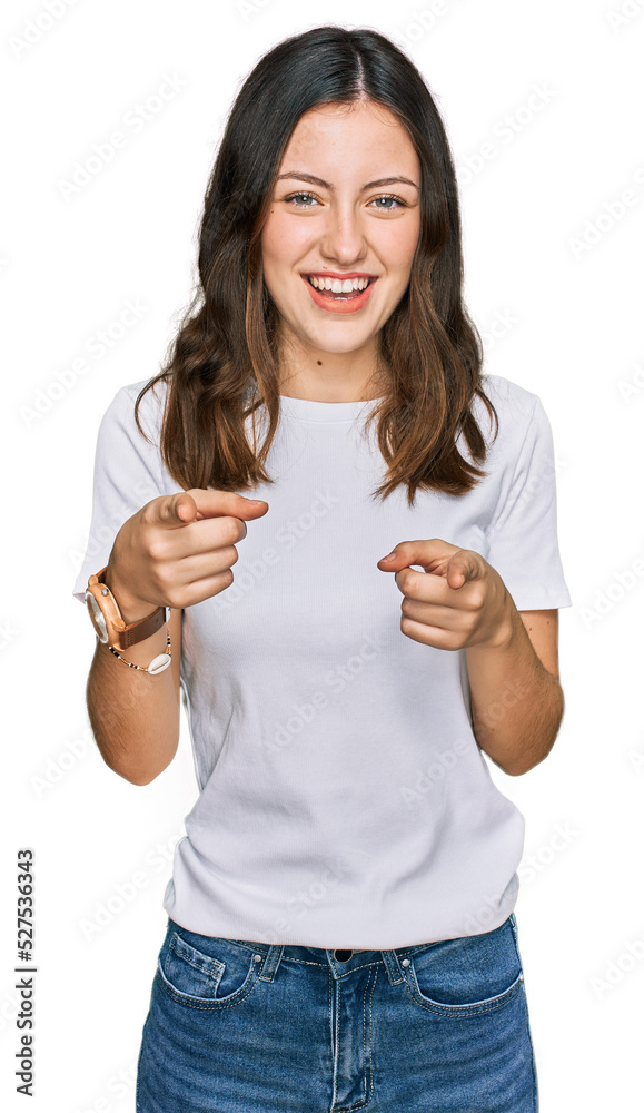 Young beautiful woman wearing casual white t shirt pointing fingers to camera with happy and funny face. good energy and vibes. Young beautiful woman wearing casual white t shirt pointing fingers to camera with happy and funny face. good energy and vibes.