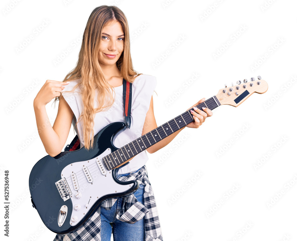 Beautiful caucasian woman with blonde hair playing electric guitar pointing finger to one self smiling happy and proud Beautiful caucasian woman with blonde hair playing electric guitar pointing finger to one self smiling happy and proud