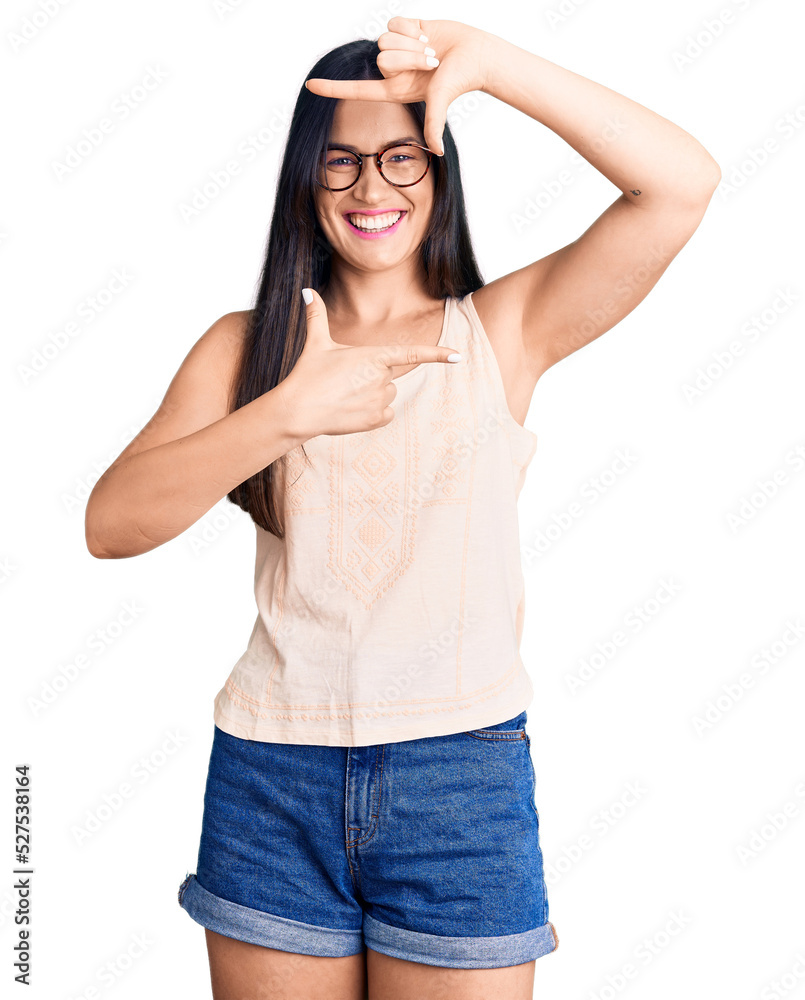 Fototapeta premium Young beautiful caucasian woman wearing casual clothes and glasses smiling making frame with hands and fingers with happy face. creativity and photography concept.