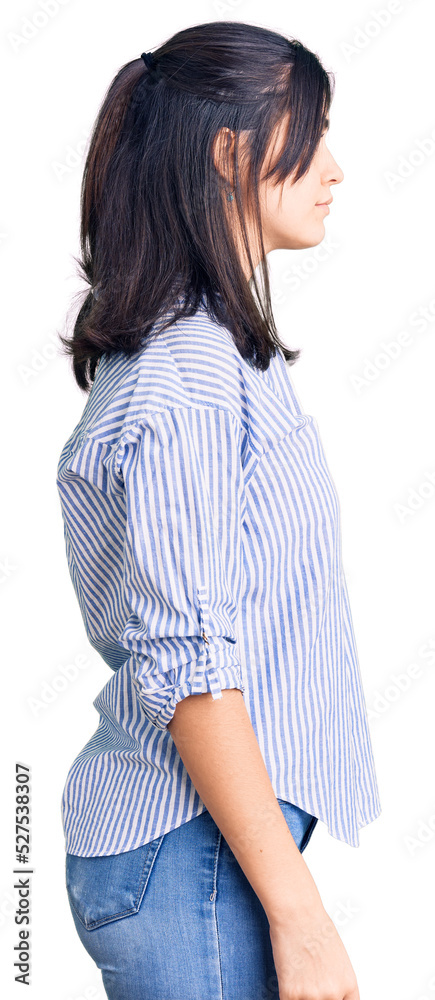Young beautiful girl wearing striped shirt looking to side, relax profile pose with natural face with confident smile. Young beautiful girl wearing striped shirt looking to side, relax profile pose with natural face with confident smile.
