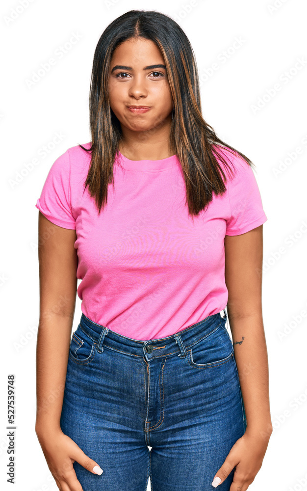 Fototapeta premium Young latin girl wearing casual clothes puffing cheeks with funny face. mouth inflated with air, crazy expression.