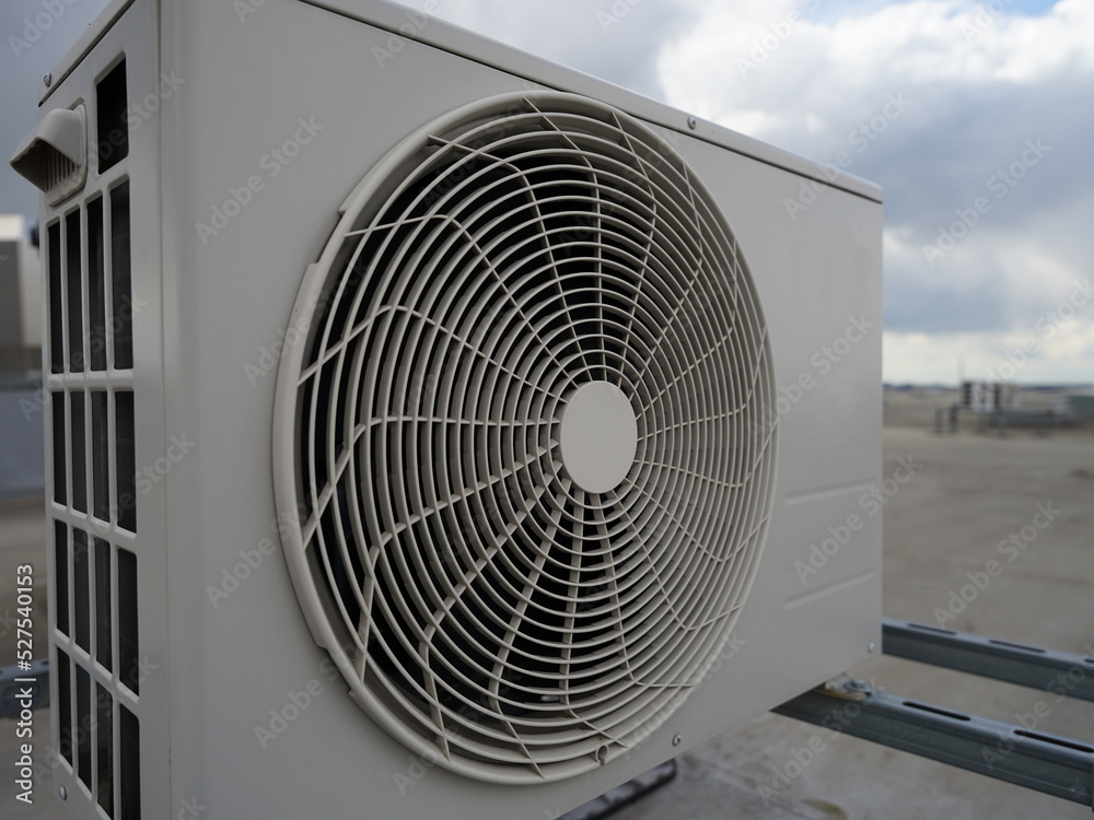 Modern industrial heat pump or air conditioning system outdoor unit on roof of industrial building, modern green renewable energy concept