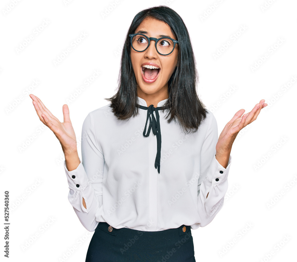 Beautiful asian young woman wearing business shirt and glasses crazy and mad shouting and yelling with aggressive expression and arms raised. frustration concept. Beautiful asian young woman wearing business shirt and glasses crazy and mad shouting and yelling with aggressive expression and arms raised. frustration concept.