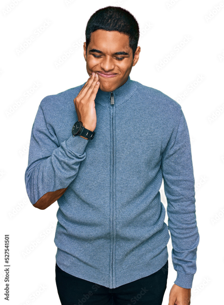 Young handsome hispanic man wearing casual sweatshirt touching mouth with hand with painful expression because of toothache or dental illness on teeth. dentist