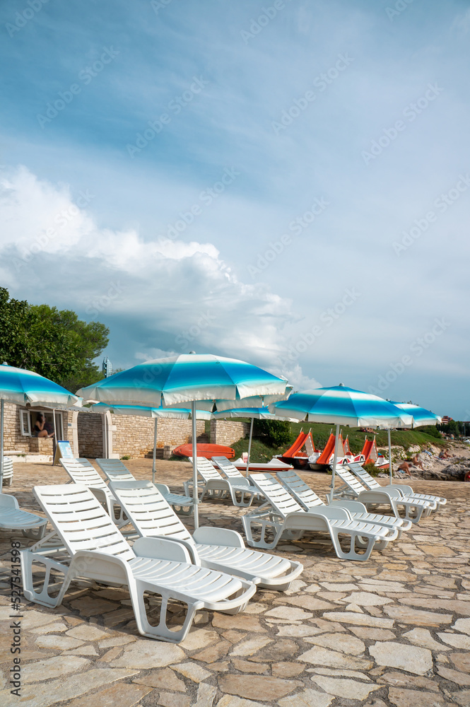 Sun loungers on the beach in Europe. Sunny beaches of Croatia