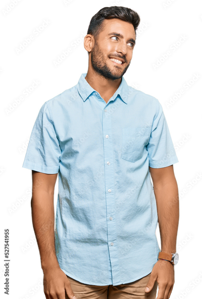 Fototapeta premium Handsome hispanic man wearing casual clothes looking away to side with smile on face, natural expression. laughing confident.