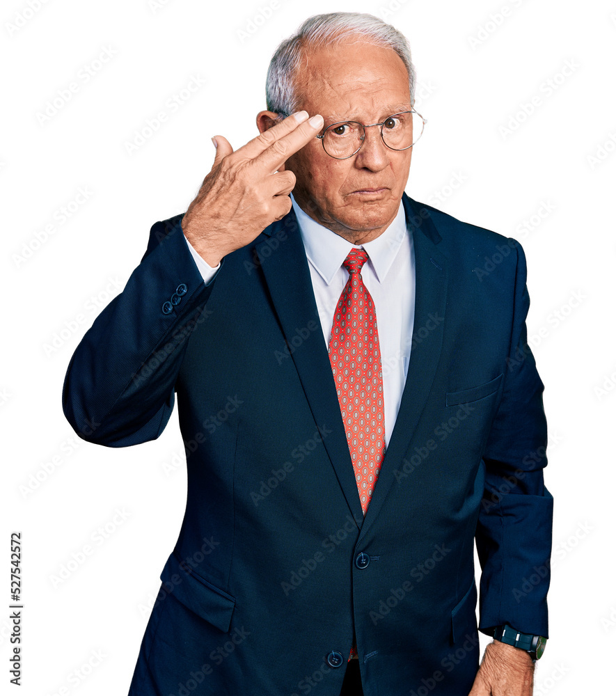 Senior man with grey hair wearing business suit and glasses shooting and killing oneself pointing hand and fingers to head like gun, suicide gesture. Senior man with grey hair wearing business suit and glasses shooting and killing oneself pointing hand and fingers to head like gun, suicide gesture.