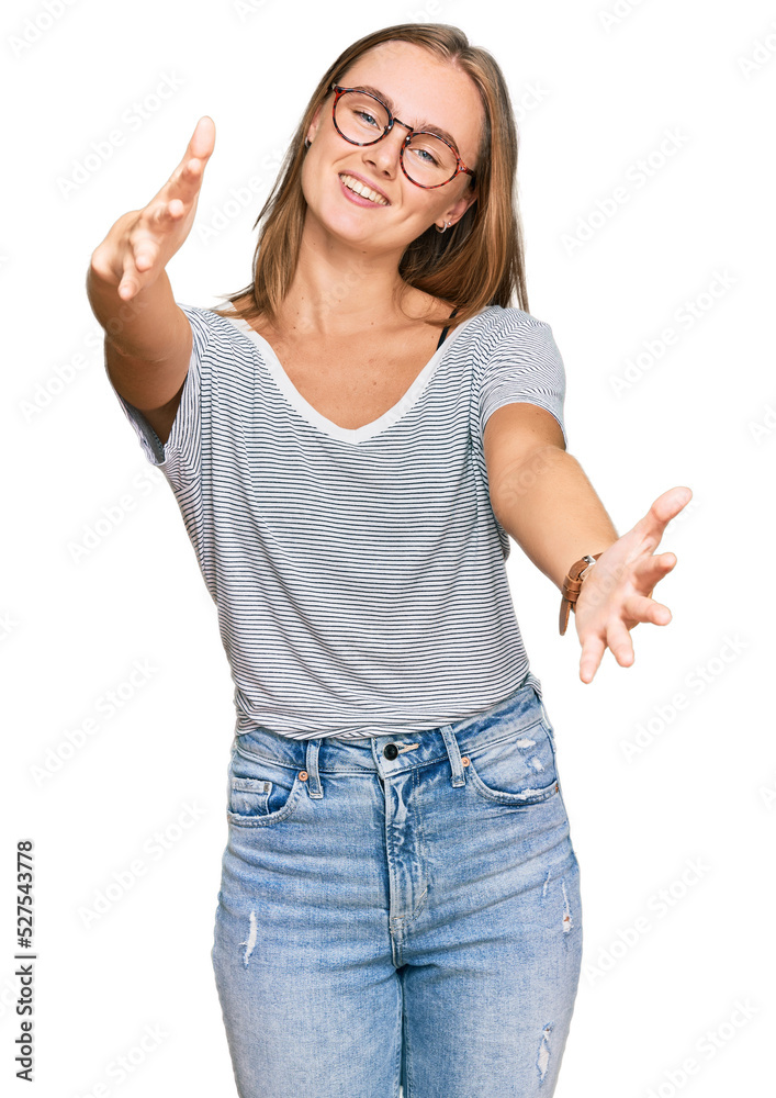 Beautiful young blonde woman wearing casual clothes and glasses looking at the camera smiling with open arms for hug. cheerful expression embracing happiness. Beautiful young blonde woman wearing casual clothes and glasses looking at the camera smiling with open arms for hug. cheerful expression embracing happiness.