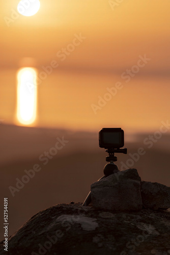 A photographers camera on a mountain on the coast at sunset