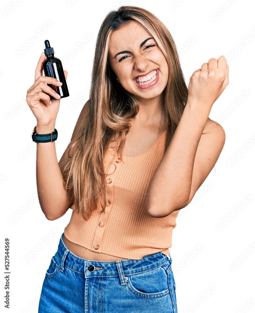 Hispanic young woman using night serum screaming proud, celebrating victory and success very excited with raised arm Hispanic young woman using night serum screaming proud, celebrating victory and success very excited with raised arm