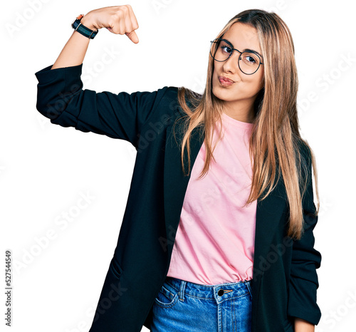 Bild auf Leinwand Hispanic young woman wearing business jacket and glasses strong person showing a