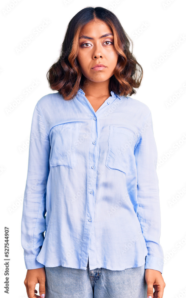 Young beautiful mixed race woman wearing casual business shirt with serious expression on face. simple and natural looking at the camera. Young beautiful mixed race woman wearing casual business shirt with serious expression on face. simple and natural looking at the camera.