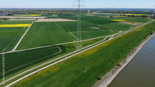 View from sky over rapeseed fields with power lines and fields and river rhine krefeld northrhine westphalia germany