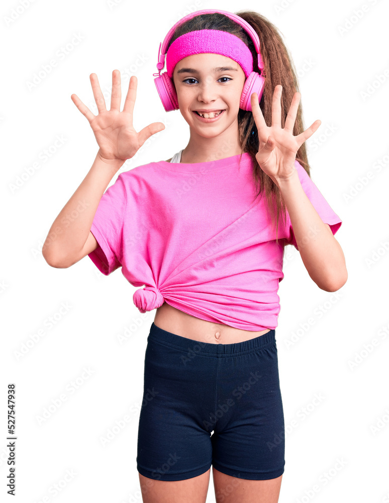 Cute hispanic child girl wearing gym clothes and using headphones showing and pointing up with fingers number nine while smiling confident and happy. Cute hispanic child girl wearing gym clothes and using headphones showing and pointing up with fingers number nine while smiling confident and happy.