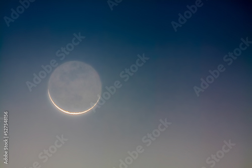 Crescent moon showing earthshine at dawn photo