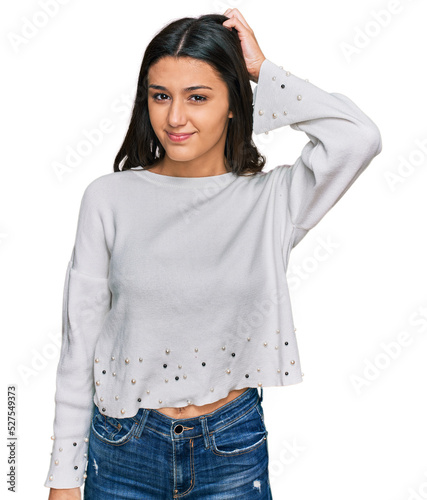 Young hispanic girl wearing casual clothes confuse and wonder about question. uncertain with doubt, thinking with hand on head. pensive concept.