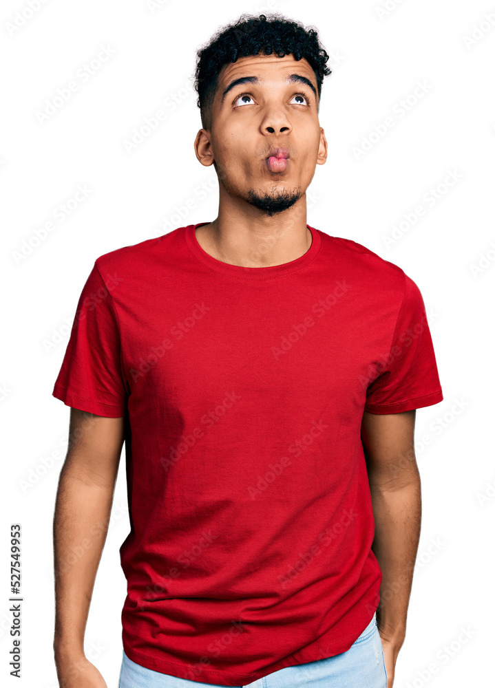Obraz premium Young african american man wearing casual red t shirt making fish face with lips, crazy and comical gesture. funny expression.