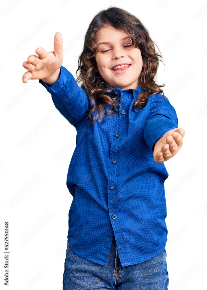Cute child with long hair wearing casual clothes looking at the camera smiling with open arms for hug. cheerful expression embracing happiness. Cute child with long hair wearing casual clothes looking at the camera smiling with open arms for hug. cheerful expression embracing happiness.