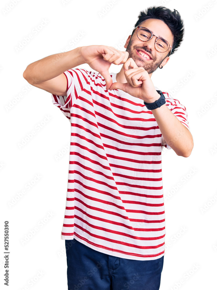 Young hispanic man wearing casual clothes smiling in love doing heart symbol shape with hands. romantic concept. Young hispanic man wearing casual clothes smiling in love doing heart symbol shape with hands. romantic concept.