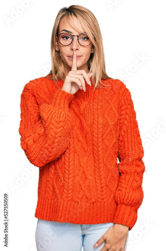 Beautiful blonde woman wearing casual clothes and glasses asking to be quiet with finger on lips. silence and secret concept.