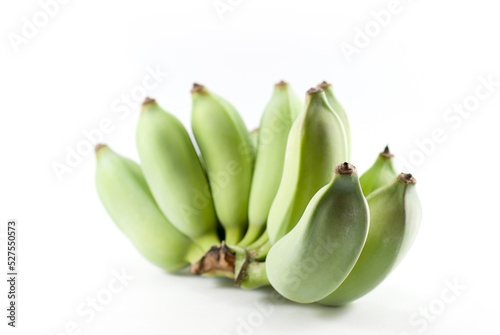 Green raw bananas are placed on a white background.