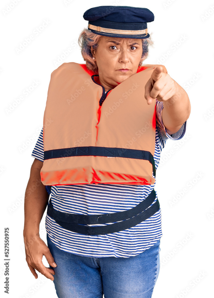 Senior woman with gray hair wearing nautical lifejacket pointing with finger to the camera and to you, confident gesture looking serious Senior woman with gray hair wearing nautical lifejacket pointing with finger to the camera and to you, confident gesture looking serious