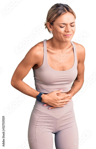 Beautiful caucasian woman wearing sportswear with hand on stomach because indigestion, painful illness feeling unwell. ache concept.