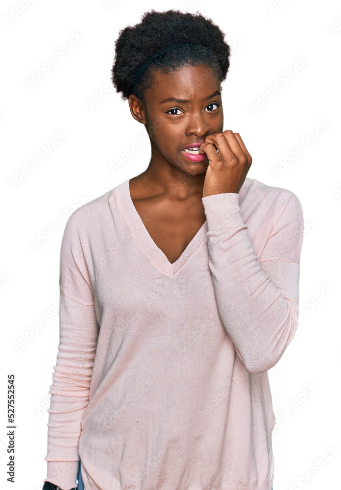 Young african american girl wearing casual clothes looking stressed and nervous with hands on mouth biting nails. anxiety problem. Young african american girl wearing casual clothes looking stressed and nervous with hands on mouth biting nails. anxiety problem.