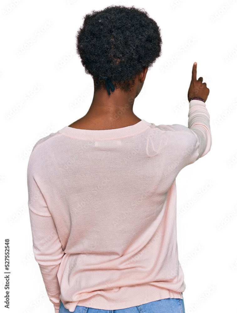 Young african american girl wearing casual clothes posing backwards pointing ahead with finger hand Young african american girl wearing casual clothes posing backwards pointing ahead with finger hand