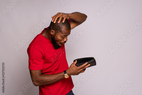 broke african man holding an empty wallet