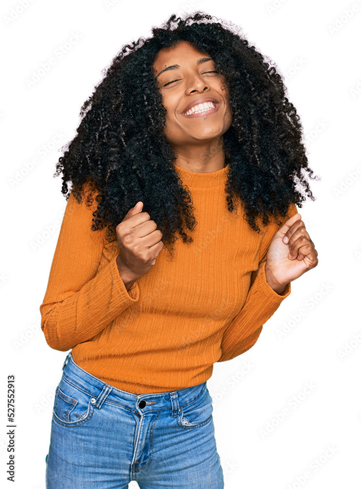 Young african american girl wearing casual clothes excited for success with arms raised and eyes closed celebrating victory smiling. winner concept. Young african american girl wearing casual clothes excited for success with arms raised and eyes closed celebrating victory smiling. winner concept.