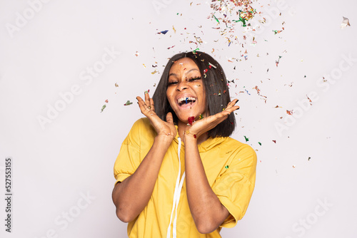 pretty african lady feeling excited and happy, with confetti photo