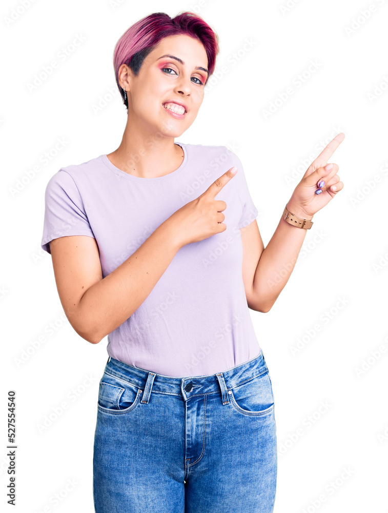 Young beautiful woman with pink hair wearing casual clothes smiling and looking at the camera pointing with two hands and fingers to the side. Young beautiful woman with pink hair wearing casual clothes smiling and looking at the camera pointing with two hands and fingers to the side.