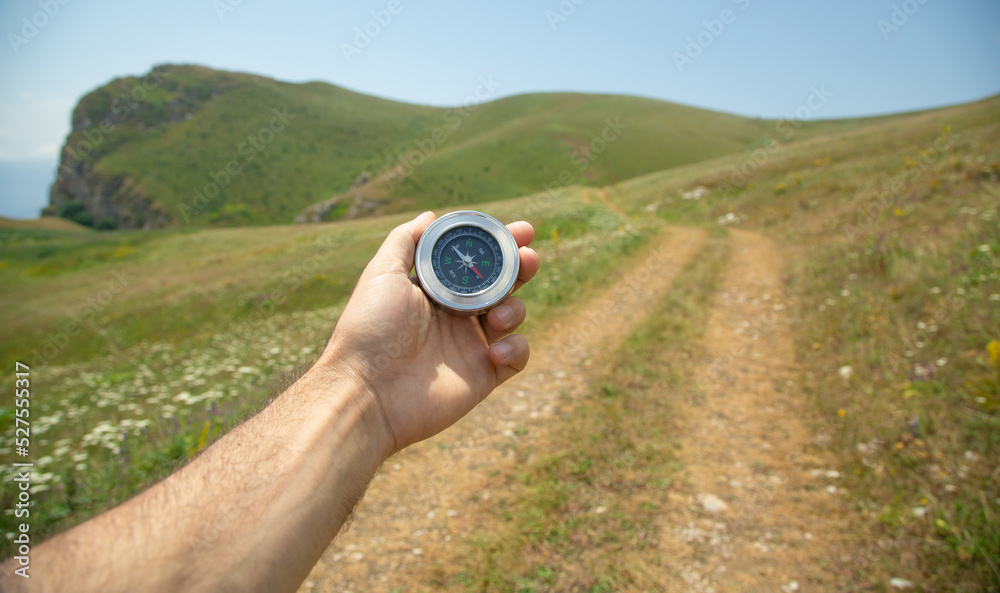 Traveler holding compass in nature background. Traveler holding compass in nature background.