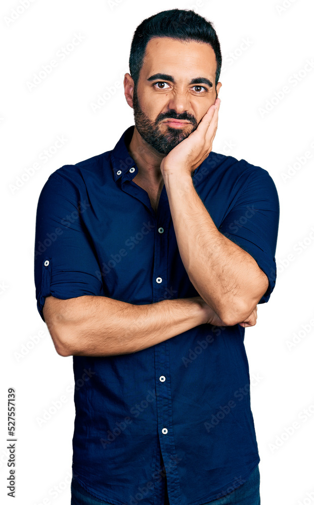 Young hispanic man with beard wearing casual blue shirt thinking looking tired and bored with depression problems with crossed arms. Young hispanic man with beard wearing casual blue shirt thinking looking tired and bored with depression problems with crossed arms.