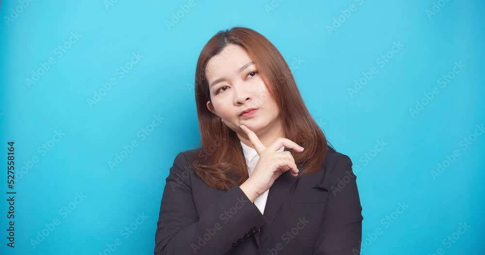 Uncertain young businesswoman thinking and looking up having idea enlightenment standing isolated over a blue background Uncertain young businesswoman thinking and looking up having idea enlightenment standing isolated over a blue background