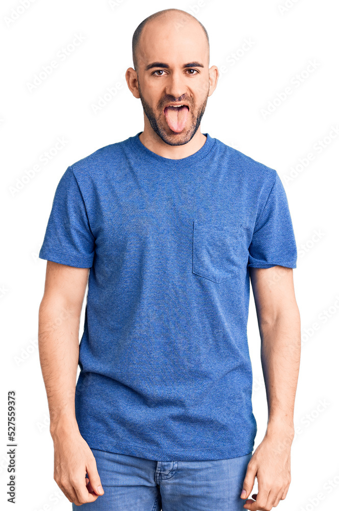 Young handsome man wearing casual t shirt sticking tongue out happy with funny expression. emotion concept. Young handsome man wearing casual t shirt sticking tongue out happy with funny expression. emotion concept.