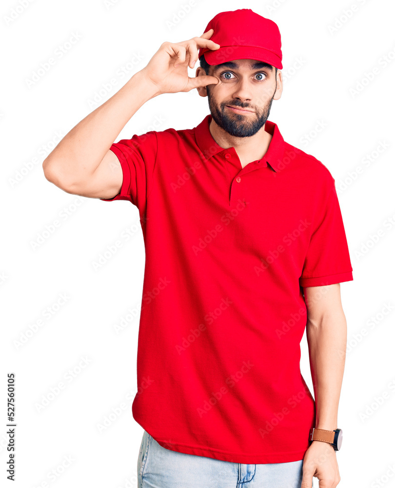 Young handsome man with beard wearing delivery uniform worried and stressed about a problem with hand on forehead, nervous and anxious for crisis