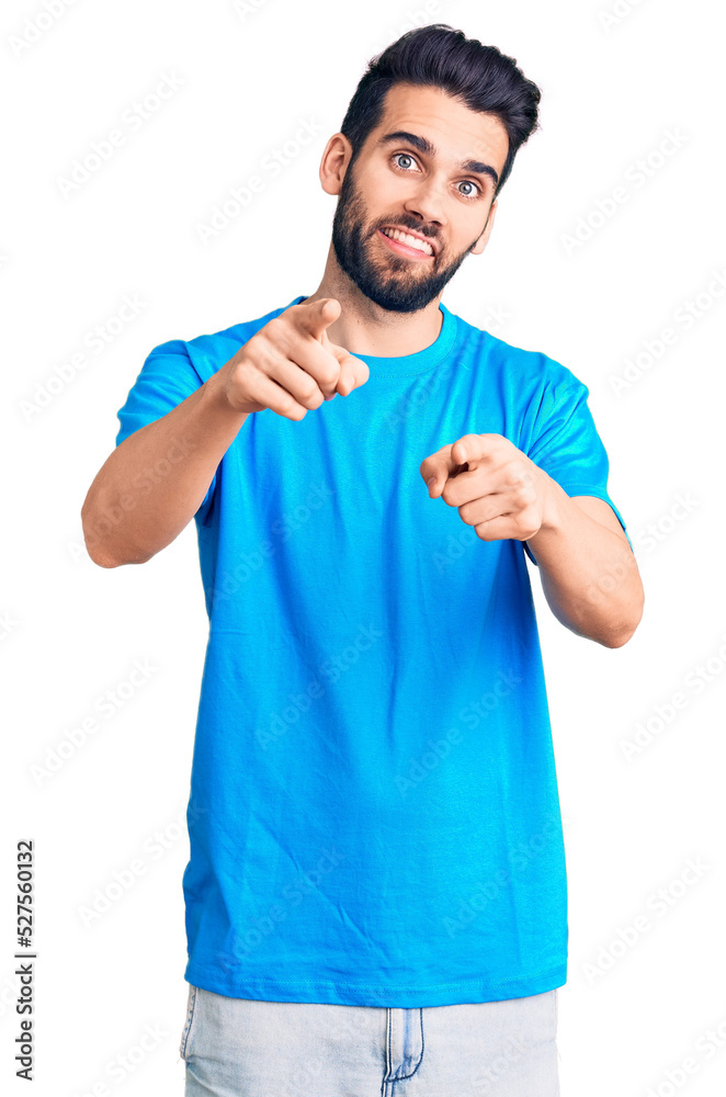 Young handsome man with beard wearing casual t-shirt pointing fingers to camera with happy and funny face. good energy and vibes. Young handsome man with beard wearing casual t-shirt pointing fingers to camera with happy and funny face. good energy and vibes.