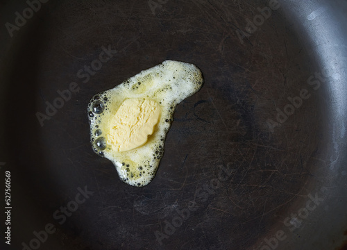 butter pat melting on a black cast iron frying pan. photo