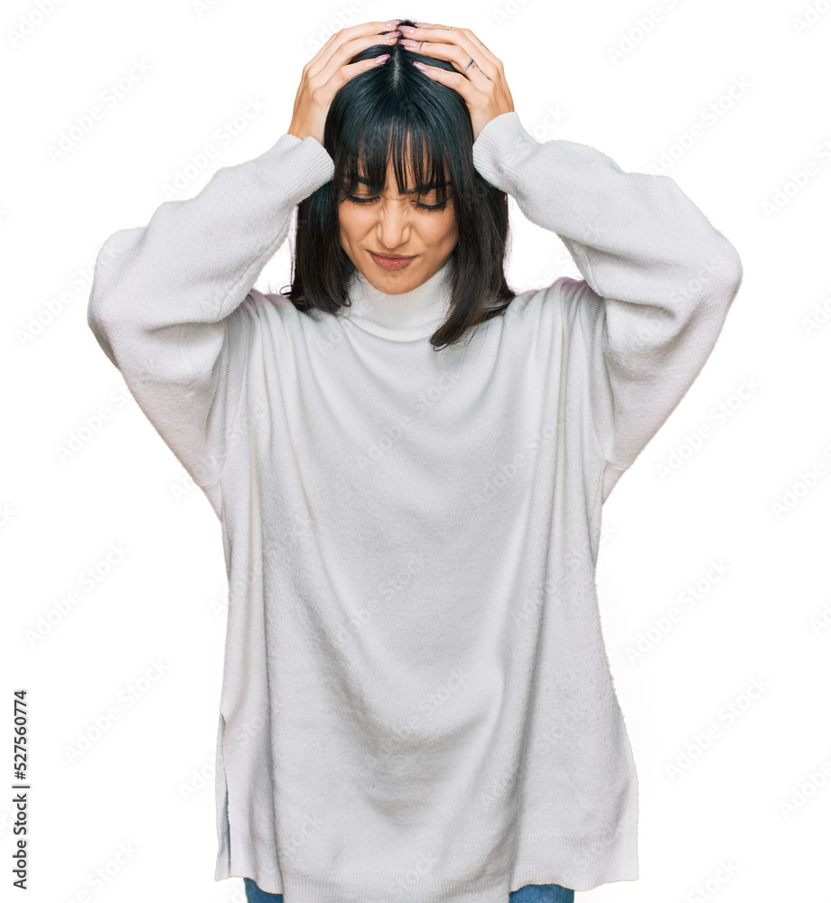 Young brunette woman with bangs wearing casual turtleneck sweater suffering from headache desperate and stressed because pain and migraine. hands on head.