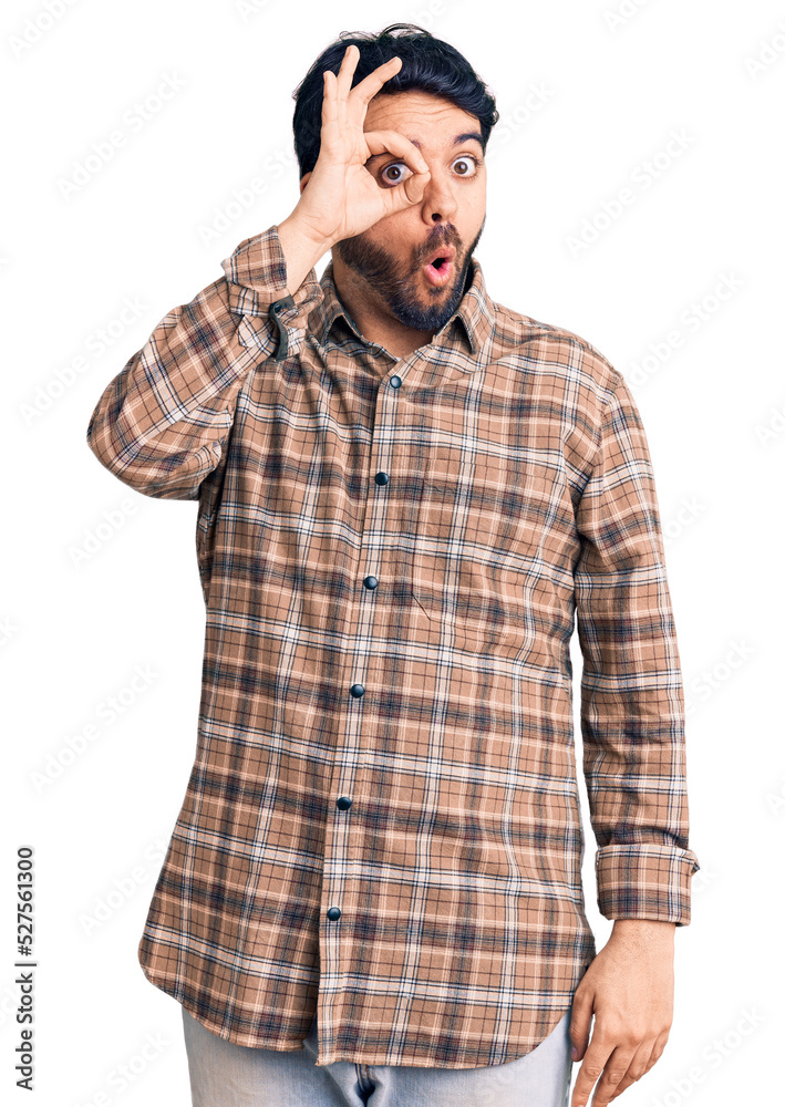 Young hispanic man wearing casual clothes doing ok gesture shocked with surprised face, eye looking through fingers. unbelieving expression. Young hispanic man wearing casual clothes doing ok gesture shocked with surprised face, eye looking through fingers. unbelieving expression.