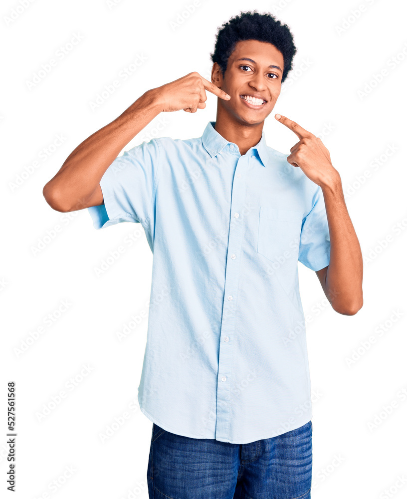 Young african american man wearing casual clothes smiling cheerful showing and pointing with fingers teeth and mouth. dental health concept. Young african american man wearing casual clothes smiling cheerful showing and pointing with fingers teeth and mouth. dental health concept.