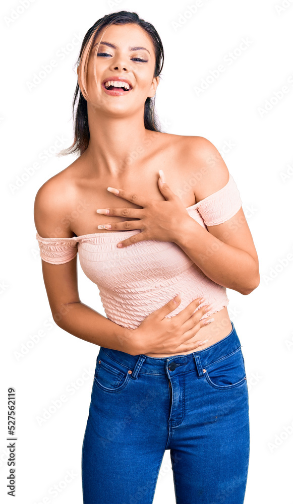 Young beautiful woman wearing casual clothes smiling and laughing hard out loud because funny crazy joke with hands on body. Young beautiful woman wearing casual clothes smiling and laughing hard out loud because funny crazy joke with hands on body.